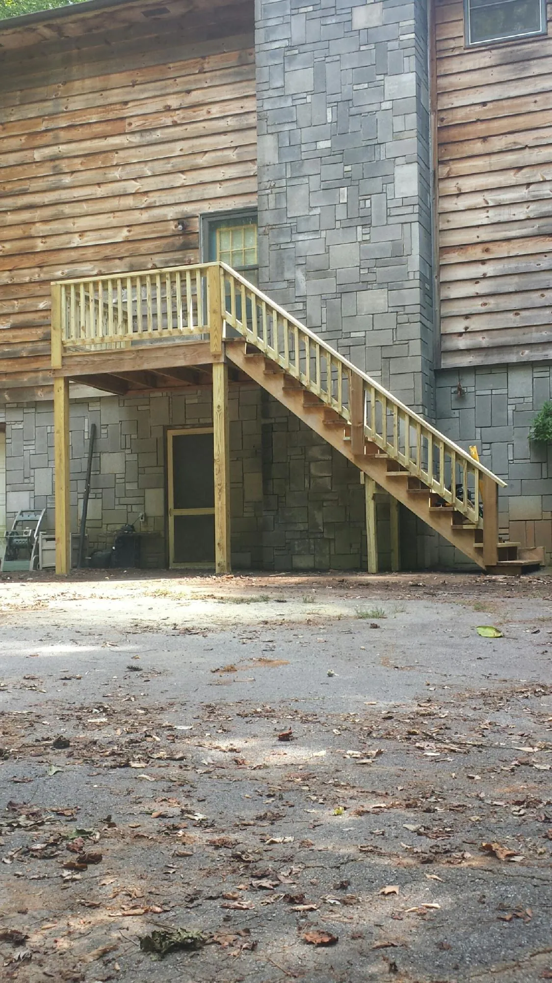 New pressure treated deck and stair landing on a log home in Moss Beach