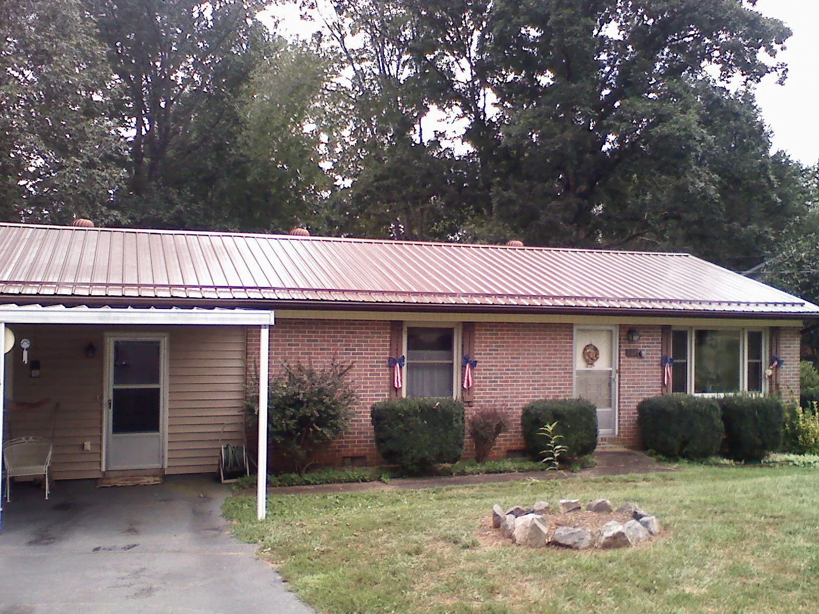Bronze metal roof and carport on a brick ranch home — Roof Repair work by our crew in Moss Beach