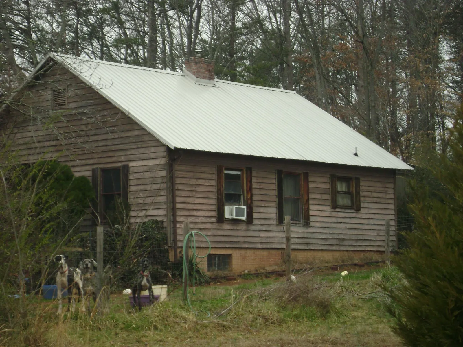 White metal roof on an old wood sided farmhouse, from a Metal Roof Installation job in Moss Beach